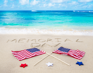 Picture of a beach with American flags supporting Memorial Day