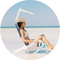Woman sitting in Sunflow chair with sun shade on beach